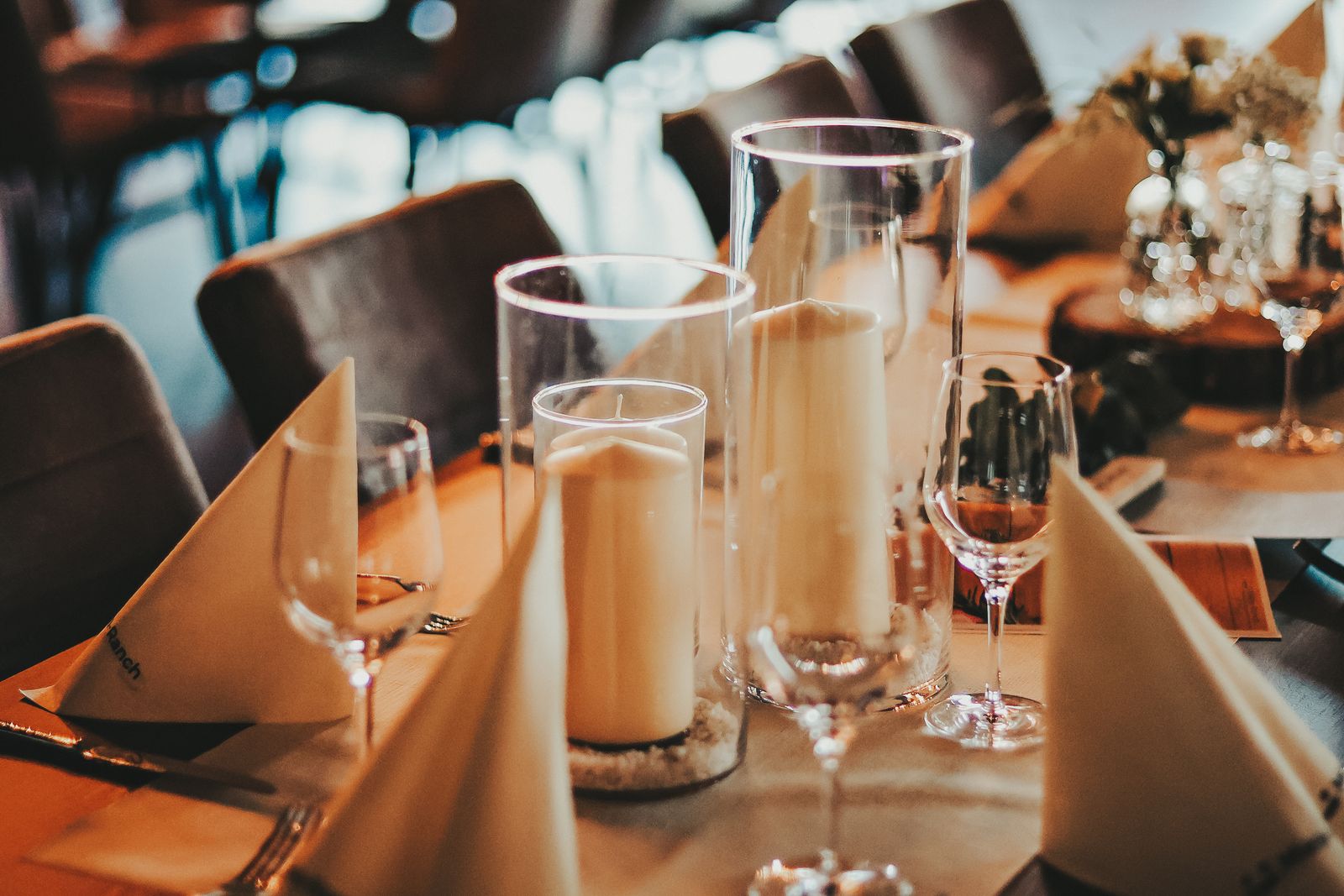 Weiße Stumpenkerzen in Glaszylindern als Tischdeko bei einer Hochzeit