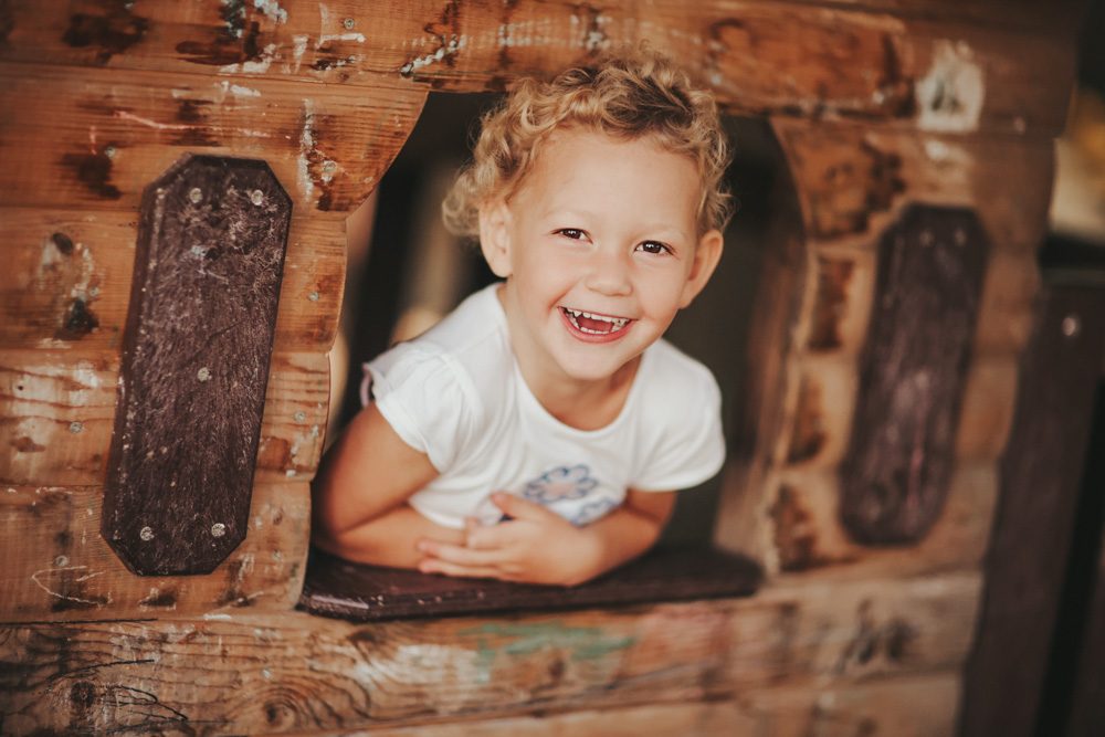 Kita-Fototag: Kind im Spielhaus-Fenster
